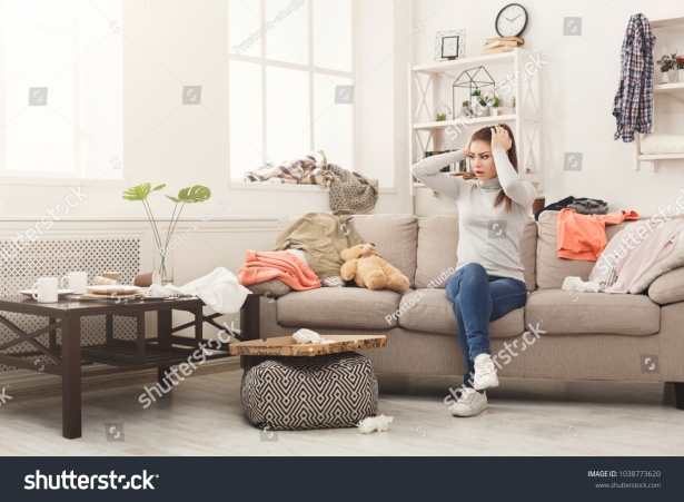 stock-photo-desperate-helpless-woman-sitting-on-sofa-in-messy-living-room-young-girl-surrounded-by-many-stack-1038773620.jpg